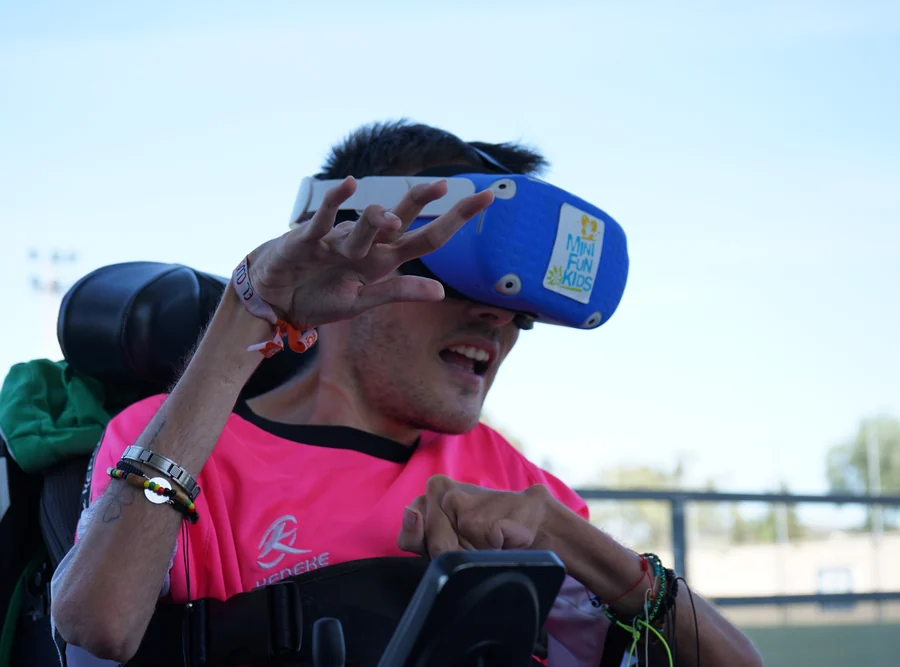 Un joven en silla de ruedas extiende la mano hacia adelante durante una experiencia de realidad virtual de Minifunkids