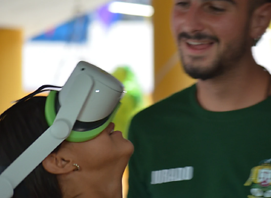 Una chica prueba unas gafas de realidad virtual de Minifunkids acompañada por un profesional que sonríe a su lado